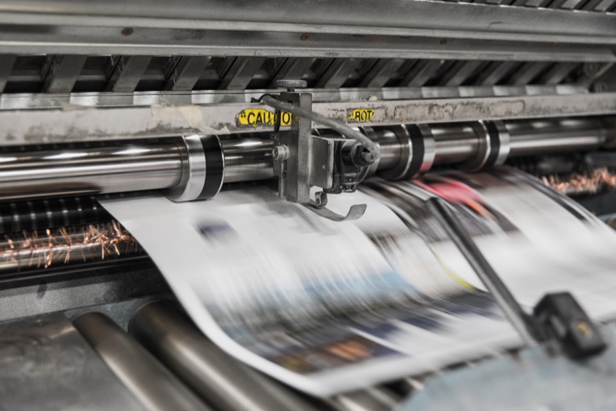 Impresión de gran formato en proceso, papel avanzando por la prensa